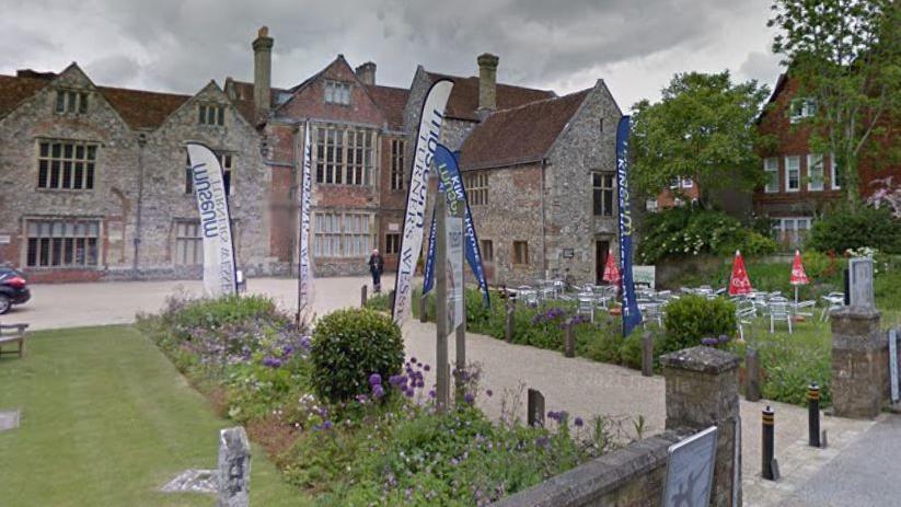 The front of Salisbury Museum, with garden out front and cafe tables