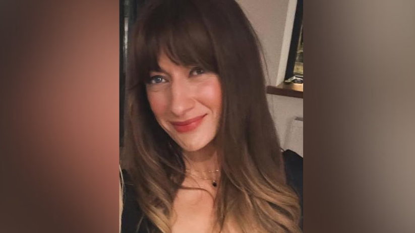 Tina Mellon, a brunette women in a selfie image wearing a black shirt. She has curly hair.