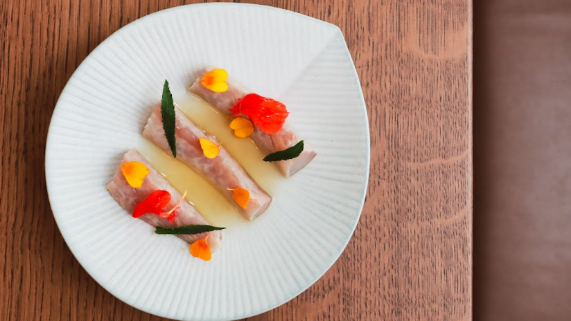 A colourful plate of food on a brown wooden table.