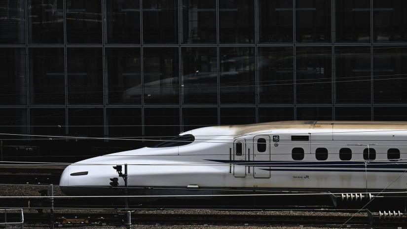Bullet train facing left as it pulls into Tokyo station. 