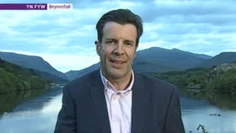 Ellis Roberts yn gohebu o'r bont yn 2019