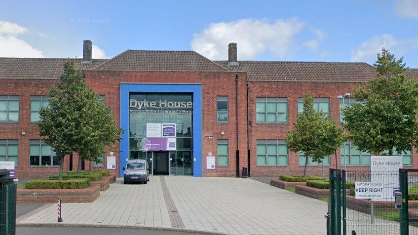 Brick school building with blue bricks and the words 'Dyke House' in large grey letters