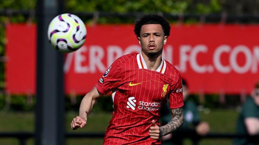 Ranel Young looking and running towards a ball which is in the air in front of him during a match for Liverpool's Premier 2 side