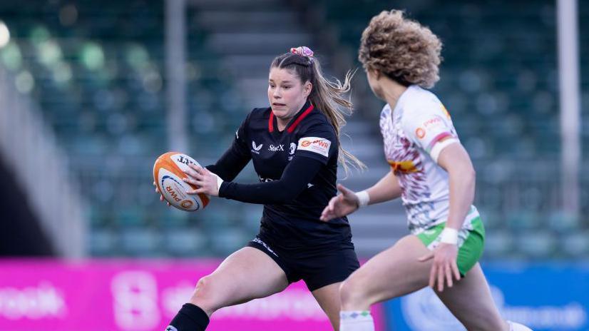 Jess Breach runs with the ball past Ellie Kildunne