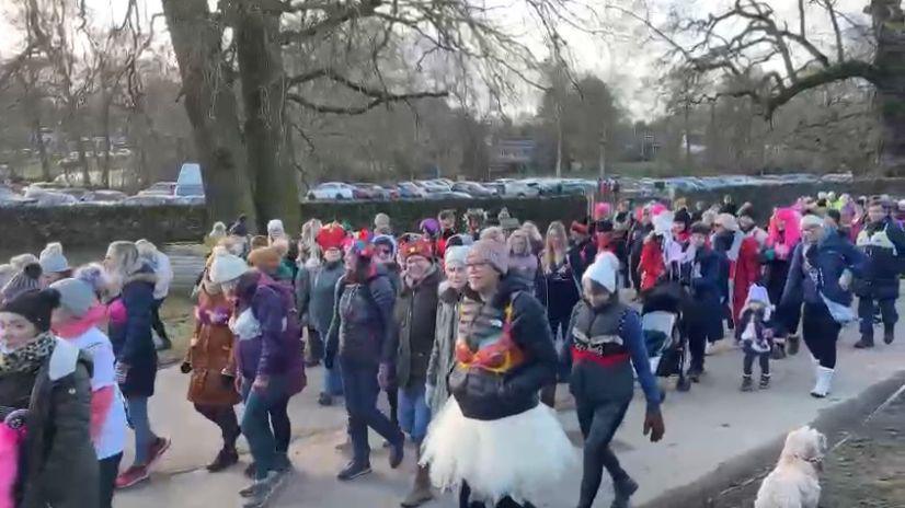 A mass of walkers with bras over their winter wear walking through Bradgate Park