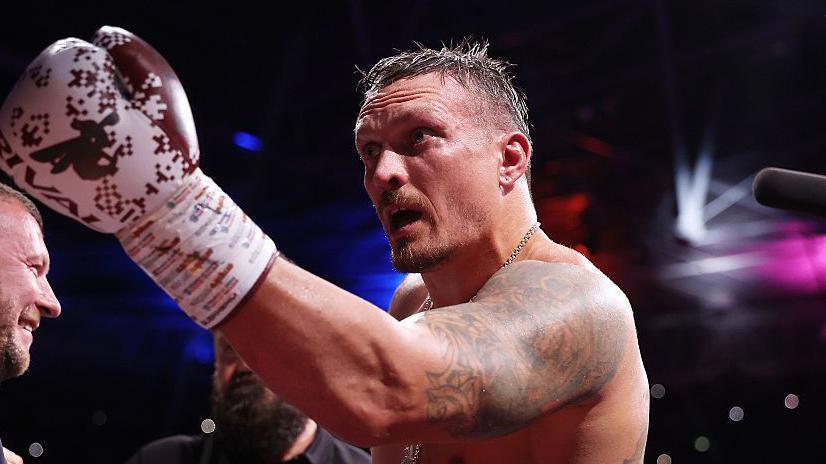Oleksandr Usyk celebrates after beating Daniel Duboi