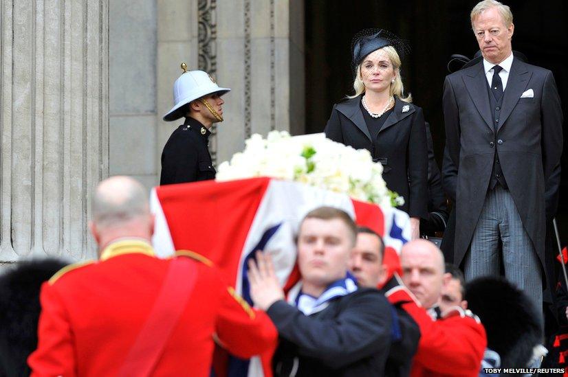 Mark Thatcher and his wife Sarah watch as the coffin of his mother is carried by military personnel outside St Paul's Cathedral after the funeral service