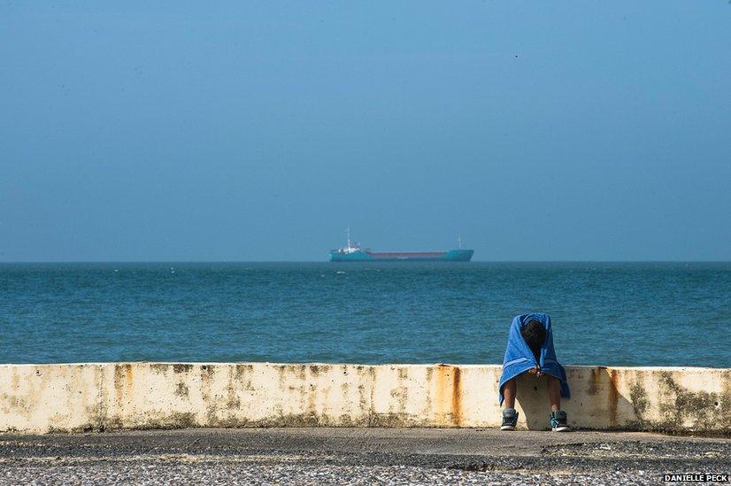 A man sits on the sea wall