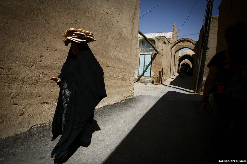 A woman carries bread on her head