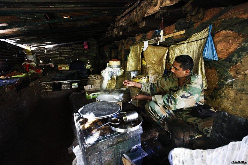 An Indian Army soldier cooks dinner in an army post in Uri, some 125 km north of Srinagar