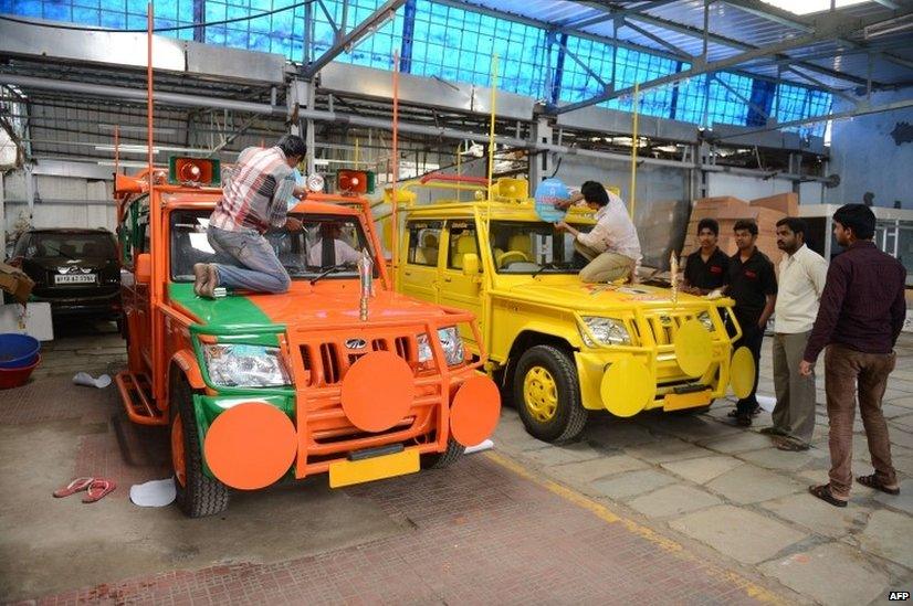 Indian workers give the final touches to election campaign vehicles bearing BJP and and Telugu Desam party (TDP) symbols and logos in Hyderabad.