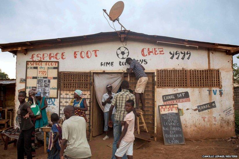 A man tries to fix the satellite equipment at a local public television hall in Petevo in the Central African Republic's capital of Bangui