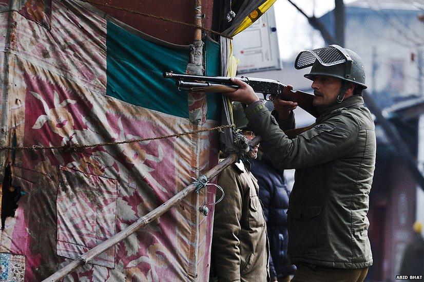 A policeman aims his pellet gun at Kashmiri protesters during a strike in Srinagar, the summer capital of Indian Kashmir, January 31 2014.