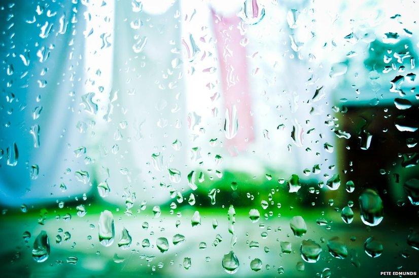 Laundry through a window covered with raindrops