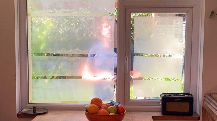 Yoghurt on a window with a man outside the window