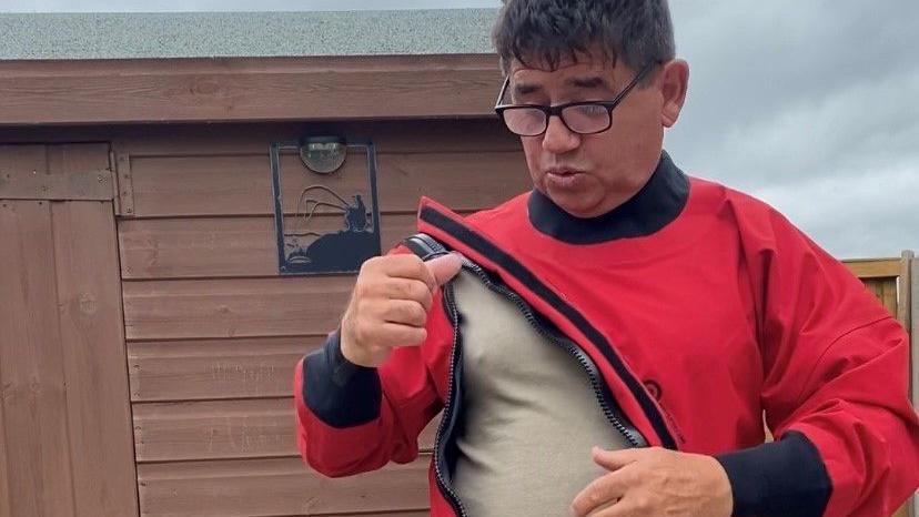 Antony Meli zipping up a drysuit