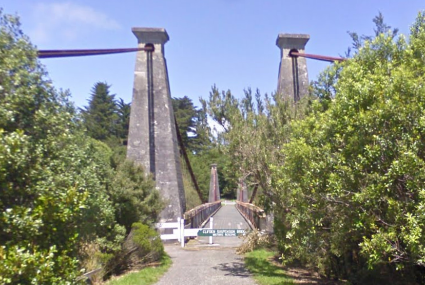 A stone suspension bridge flanked by trees