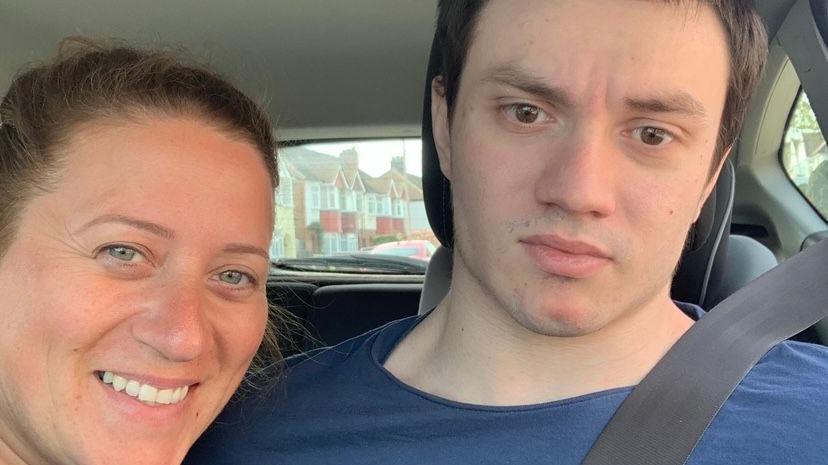 Sophie Ticehurst, left, takes a selfie photo with her brother Jack, right, in the front seats of a car. Sophie has light brown hair tied back. Jack has short dark brown hair and wears a navy blue t-shirt. 