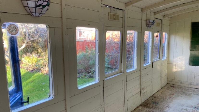 The inside of the former passenger carriage.  It is made of wood and painted white.