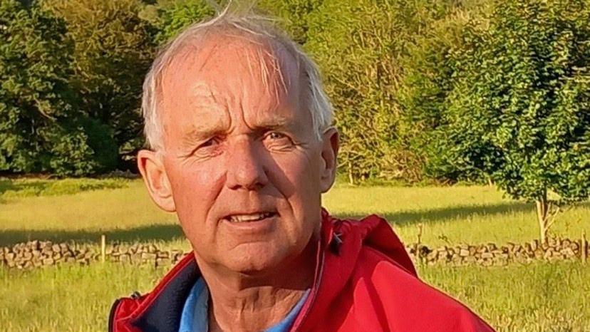 Neil Roden outdoors wearing a red jacket