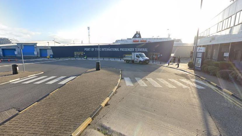 A general view of the outside of the Port of Tyne International Passenger Terminal with a ferry in the background and a flat-bed truck parked outside