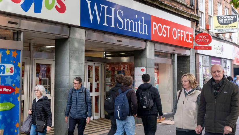 People walk by a Toys R Us and Post Office within the WH Smith store in November 2024 in Shrewsbury, United Kingdom. 