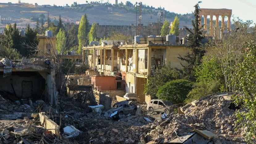 The ancient Roman ruins of Heliopolis are seen in the background of an image showing damage and rubble from an Israeli strike in Lebanon