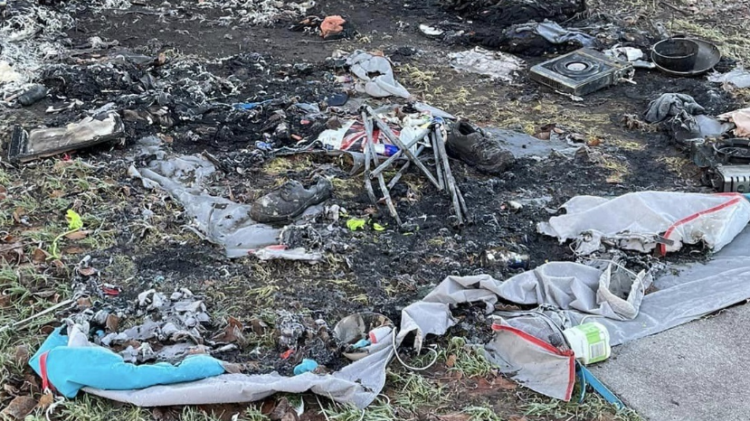 Scorched ground with remnants of burned tents