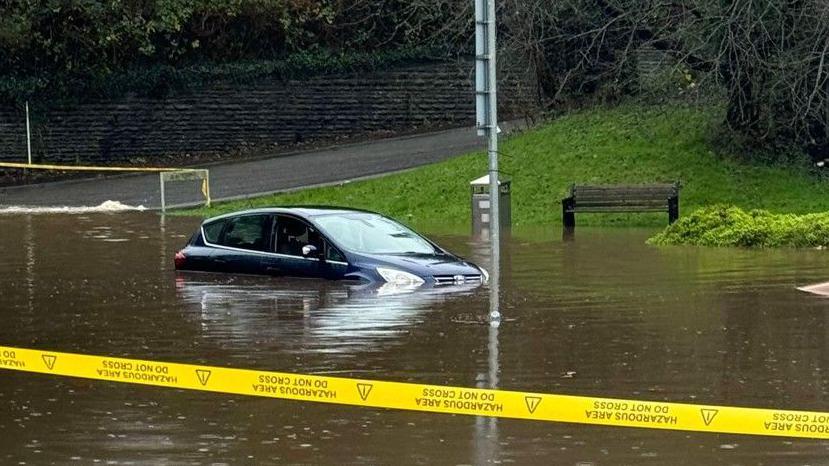 Cordon around flood water with a vehicle partly submerged