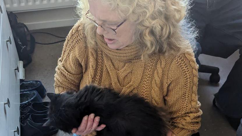 A woman holds a cat