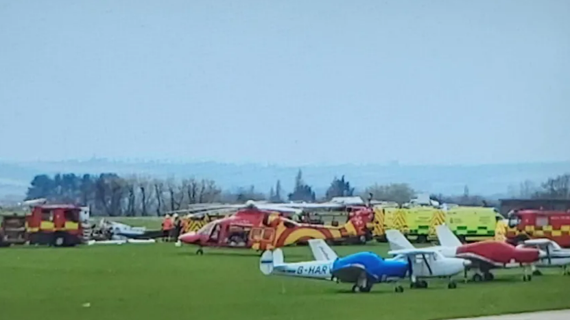 Emergency services and stationary planes parked in a field at Imperial War Museum (IWM) Duxford