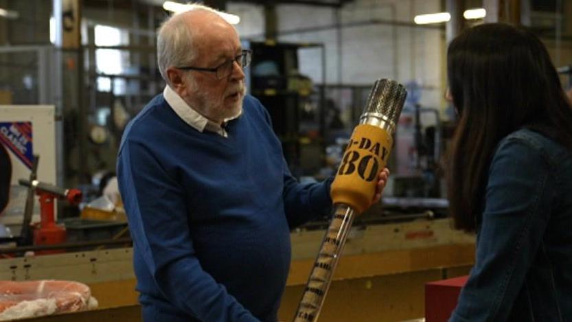 A man holding a commemorative torch handle