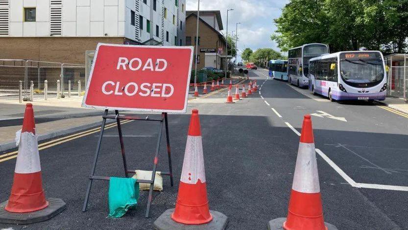 Traffic cones and a road closed sign on one side of Vicar Lane