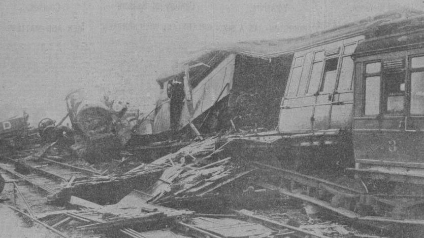 A black and white photo showing the damaged trains
