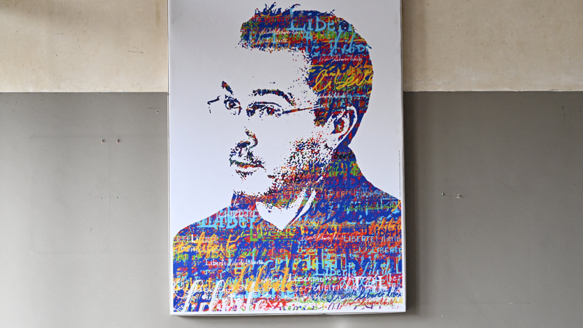 A photograph taken on October 16, 2023 shows a portrait of slain French teacher Samuel Paty during a tribute ceremony at the Bois d'Aulne school in Conflans-Sainte-Honorine, outside Paris. France 