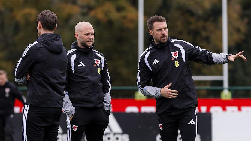 Aaron Ramsey gyda aelodau o dîm hyfforddi Cymru