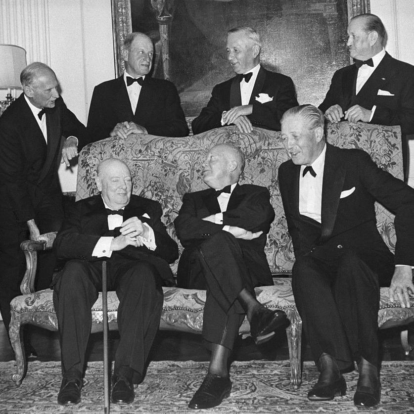 A black and white photo of men in tuxedos, seated (left to right) are former British Prime Minister Sir Winston Churchill, Eisenhower, and Prime Minister Harold MacMillan. Standing (left to right) are Field Marshall Viscount Montgomery; Lord Portal; Sir Arthur Tedder, and Lt Gen Sir Frederick Morgan, Eisenhower's Deputy Chief of staff during the war.