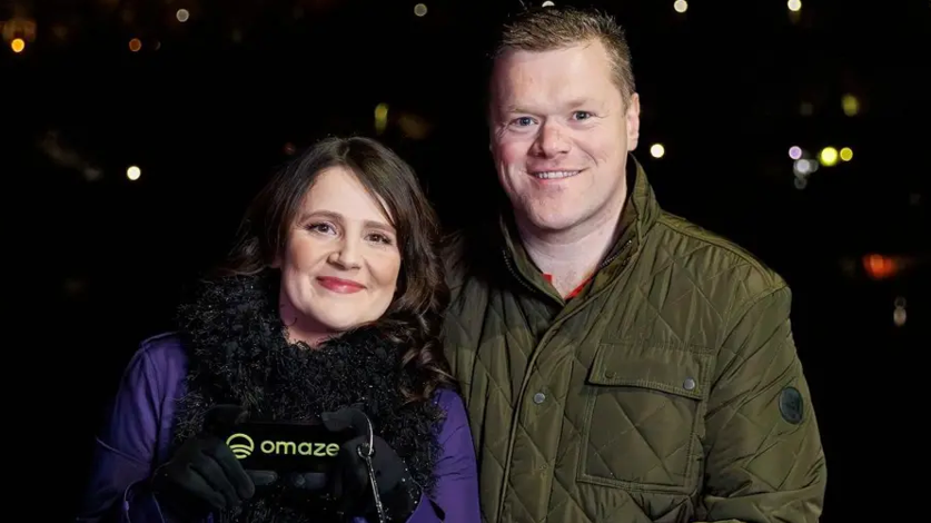 Vicky Curtis-Cresswell and her husband Dale. Vicky, on the left, is smiling. She has long dark hair and is wearing a blue top, a black scarf and black gloves. Her husband is also smiling. He has short, brown hair and is wearing a green padded jacket.