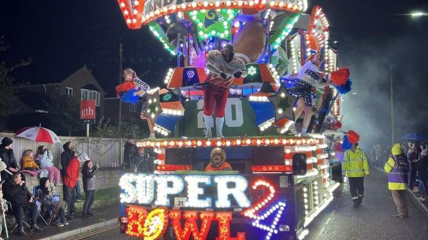 A brightly decorated carnival cart with a  super bowl theme.