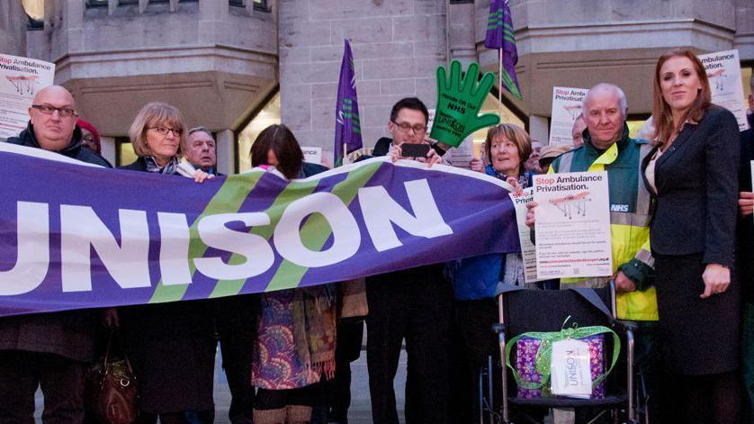 Angela Rayner with members of Unison and protesters from Save Our Ambulance Service on their way to the Department of Health. They hold a purple sign reading Unison.