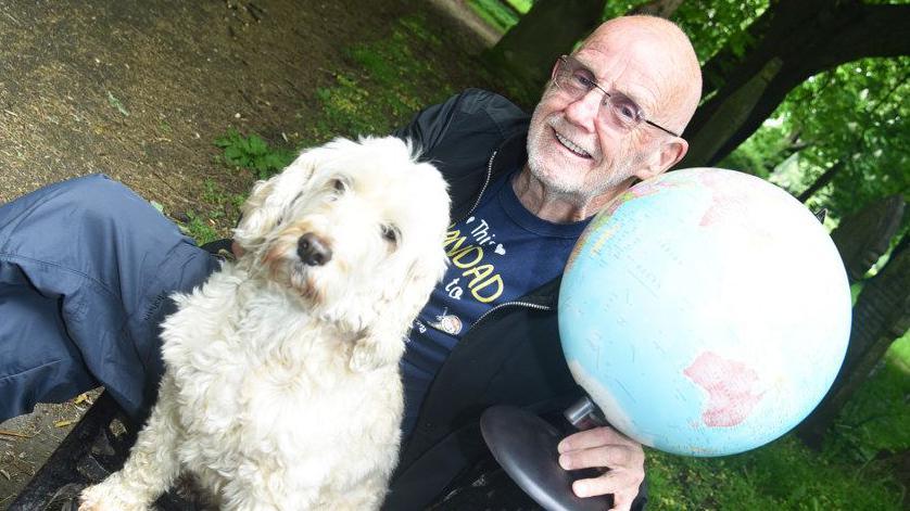 Ian Mawson, cockapoo Ollie and a globe