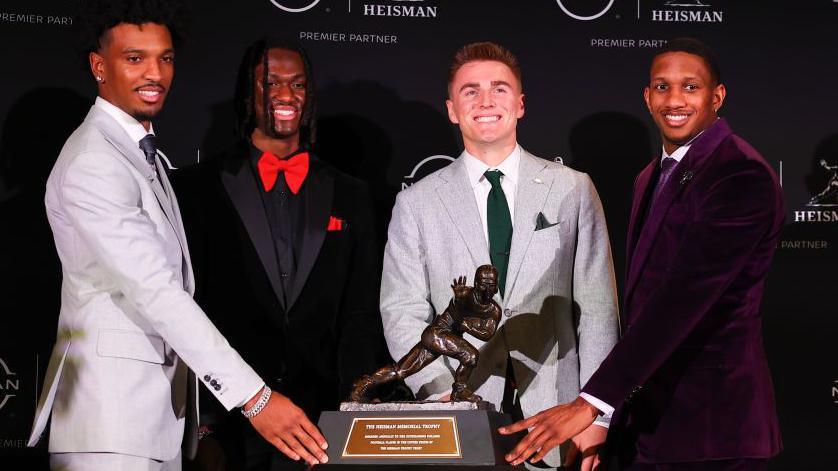 Finalists Jayden Daniels, Marvin Harrison Jr, Bo Nix and Michael Penix Jr pose with the Heisman Trophy in 2023