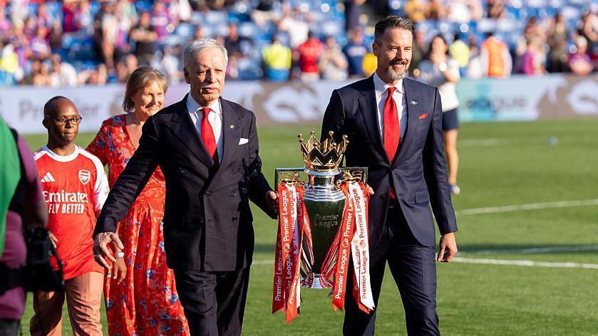 Josh and Stan Kroenke walk trophy out onto pitch