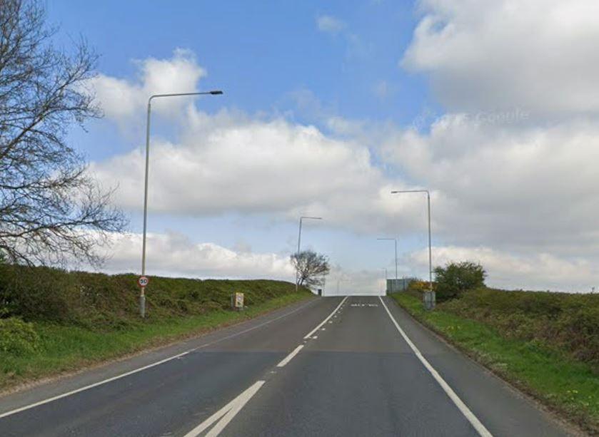 Open road view with a central white line and grass verges on eith side
