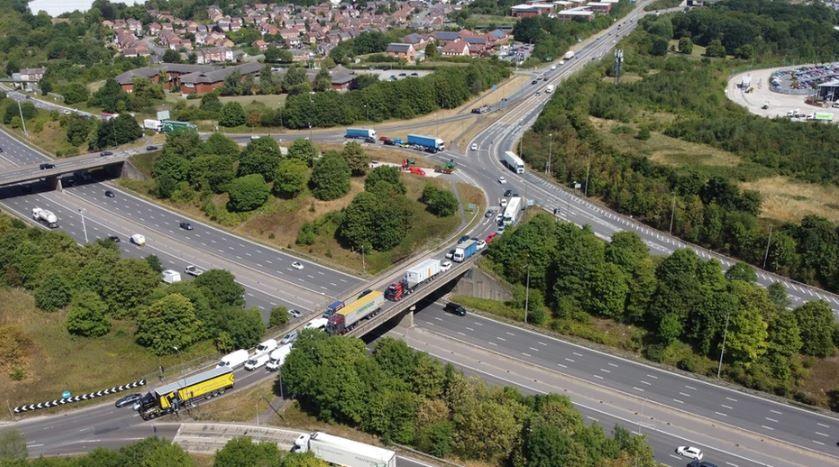 An aerial view of the flyover roundabout at J28 Pinxton. There is heavy traffic on the roundabout and includes HGVs and cars. 