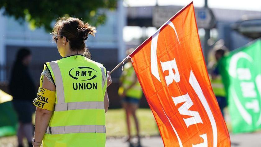 RMT union member holding flag.