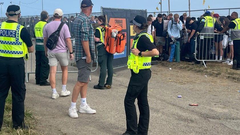 Police and crowds at the Boardmasters site where queues of people are waiting to get in. Police are wearing high-viz jackets