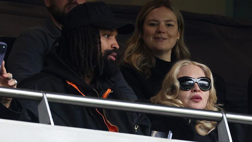 Madonna, American singer-songwriter and record producer, and Akeem Morris, watch on from the stands during the Barclays Women's Super League match between Tottenham Hotspur and Chelsea