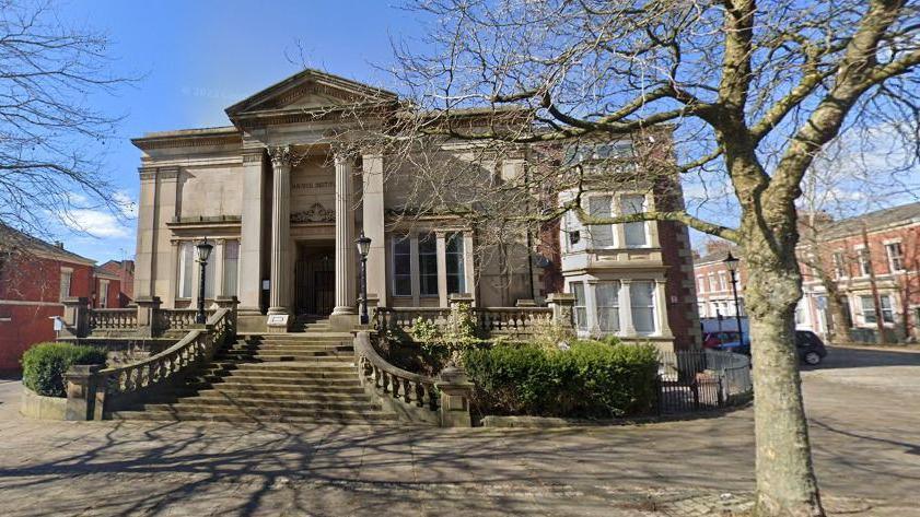 The Harris Institute, Preston, a large light stone building with tall columns at the large door entrance, and steps lead up to it in the autumn sunshine