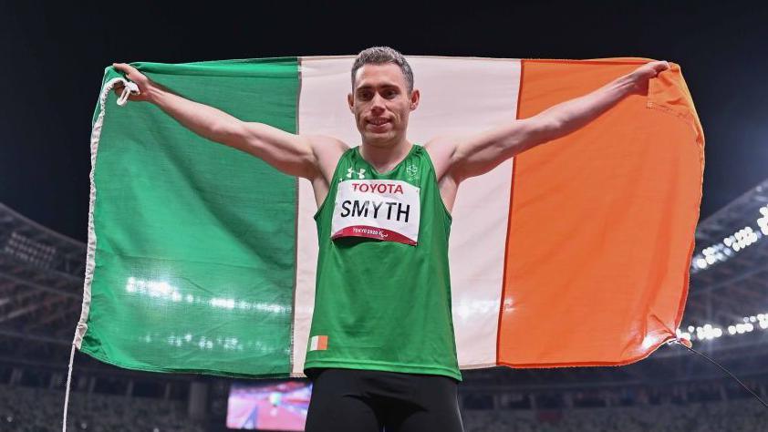 Jason Smyth of Ireland celebrates with the tricolour after winning the T13 Men's 100 metre final at the Olympic Stadium on day five during the Tokyo 2020 Paralympic Games in Tokyo,